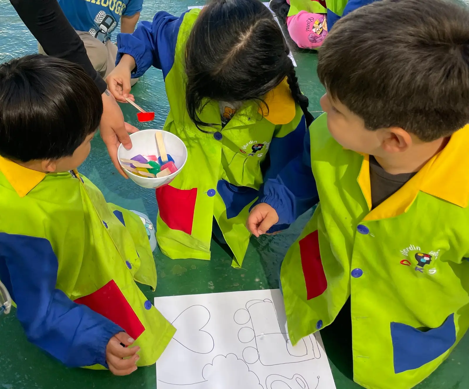 Niños del Jardín Infantil CKS explorando colores y formas en una actividad de arte