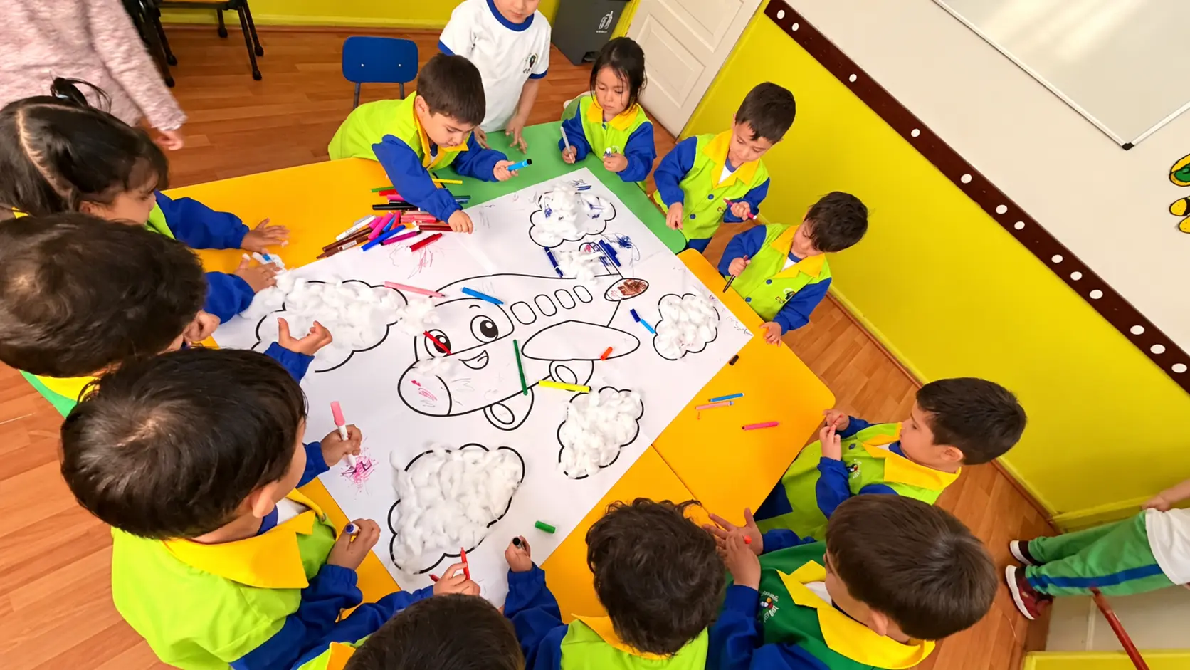 Niños crean juntos un avión con lápices y algodón en la sala