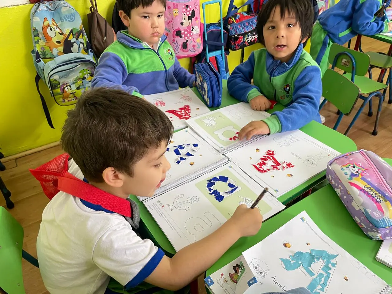 Niños de Transición Menor aprenden con dibujos y collage en sus cuadernos